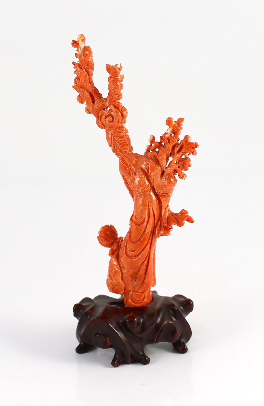 A Chinese carved coral figure of a flower fairy, 20th century, the carving 19cm high and 119g, wood stand